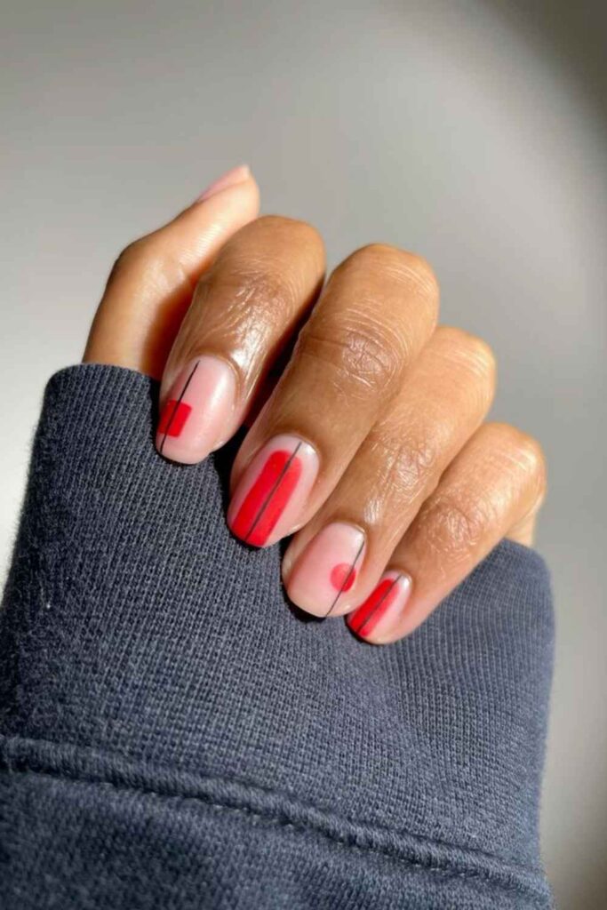 32 Red Acrylic Nail Designs That Always Look Like You Just Left the Salon 12 Red Abstract Brushstroke Nails on a Nude Base