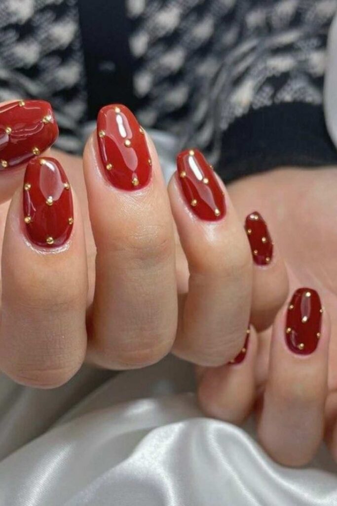 32 Red Acrylic Nail Designs That Always Look Like You Just Left the Salon 9 Strawberry Red Nails with Tiny Gold Studs Along the Cuticle